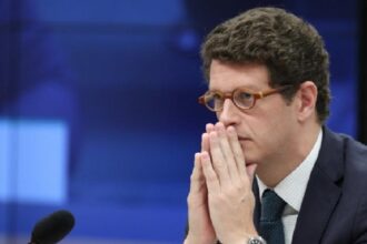 O deputado federal Ricardo Salles (PL-SP) de perfil, de óculos, com expressão pensativa e mãos unidas próximas ao rosto